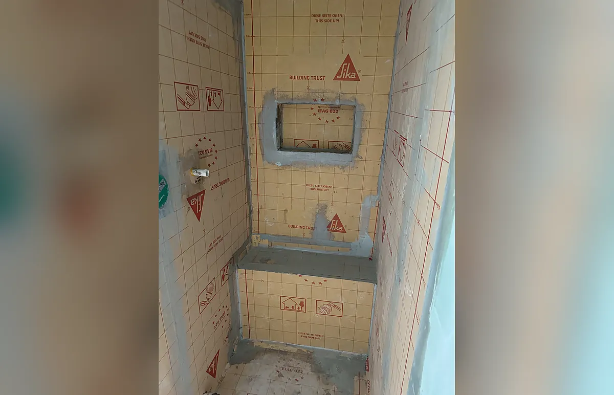 Abgedichtete Dusche mit Sitzbank und Nische vor der Belagsverlegung